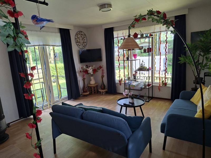 Woonkamer met grote ramen en bloemenslingers